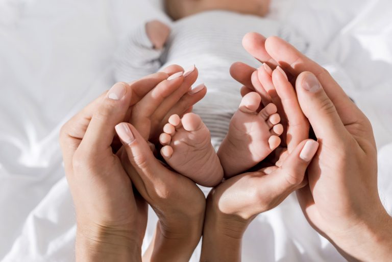 parents holding a newborn's feet